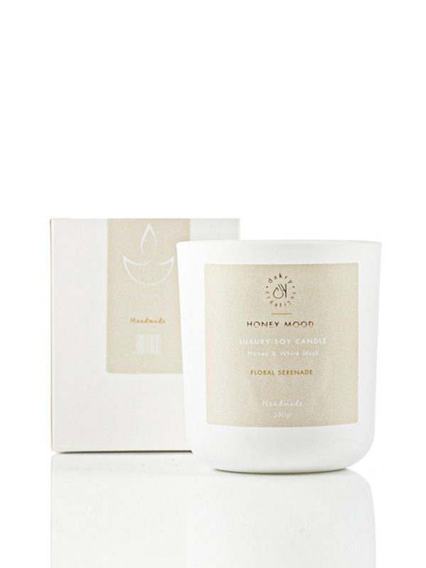 Honey and white musk scented soy candle in a glass jar